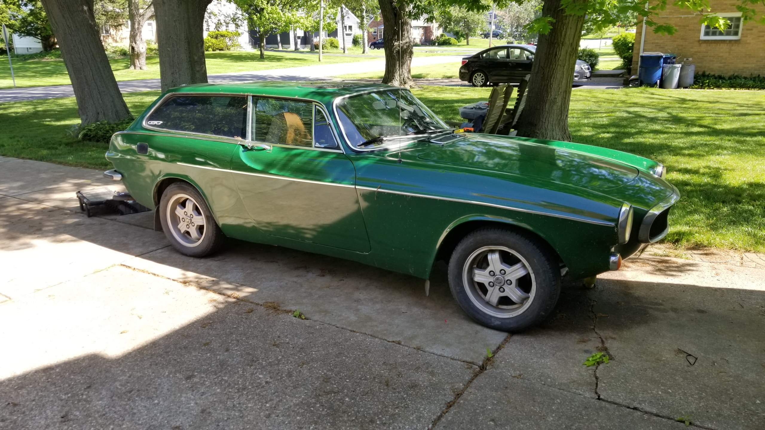 Green vintage car parked residential street