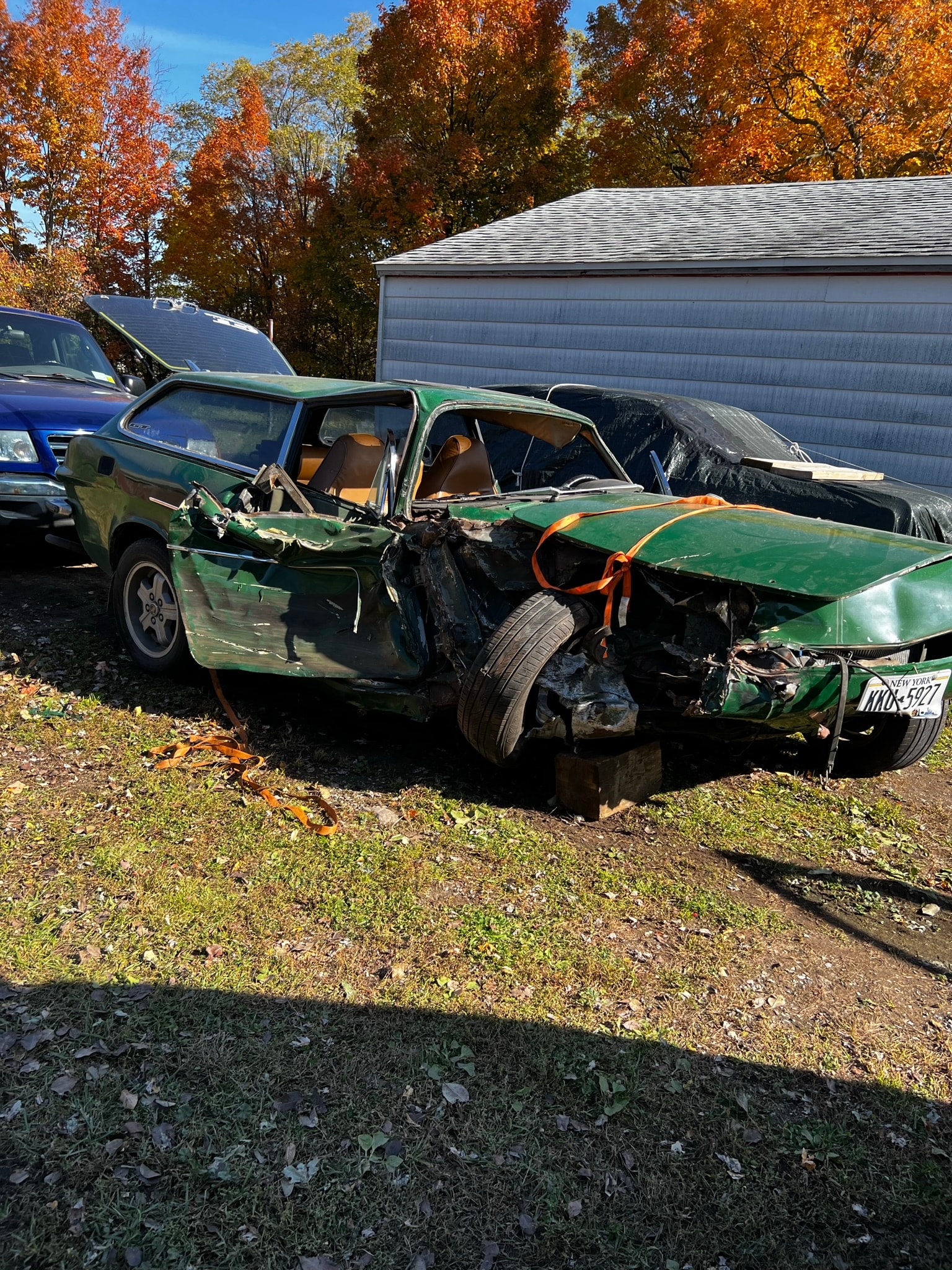 Severely damaged green car wreckage
